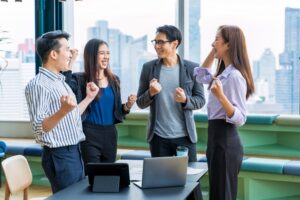 QUÉ ES UN EQUIPO FUNCIONAL CRUZADO grupo de personas realizando una dinámica de motivación en la oficina