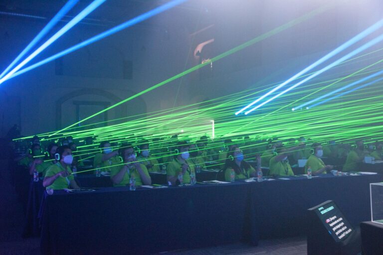 luces verdes de efecto láser y asistentes con audífonos en molecula haleon convencion 2023