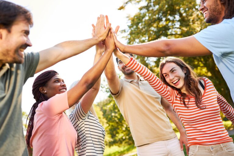 equipo jchocando las manos en actividad de Team Building