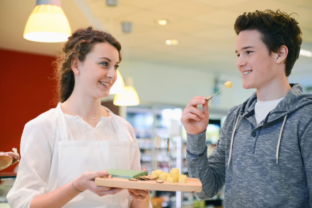 Sales,Assistant,Offering,Customer,Cheese,In,An,Organic,Grocery,Store